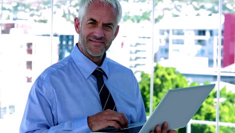 businessman using his tablet and smiling