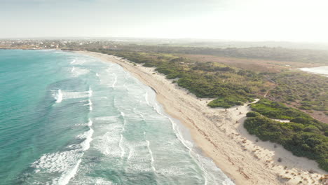 Mar-Azul-Cristalino-Con-Olas-Salpicando-En-La-Playa-De-Arena-Fina-En-La-Reserva-Natural-De-Vendicari,-Sicilia,-Italia