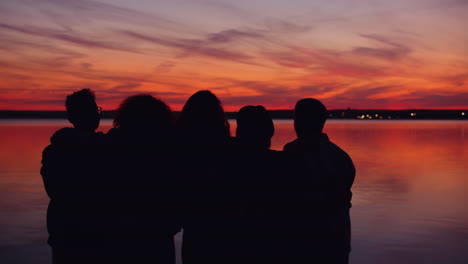 friends watching sunset by the lake