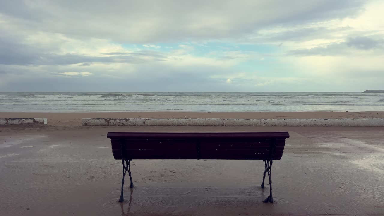 bench against the backdrop of the sea or ocean with waves and a beautiful sky with clouds