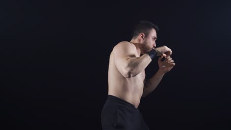 Boxing-against-black-background,-shadow-boxing.-To-practice.