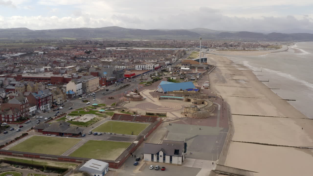 una vista aérea del paseo marítimo de rhyl y el paseo marítimo en un día nublado, volando sobre el paseo marítimo hacia la bahía de kinmel, norte de gales, reino unido
