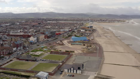 An-aerial-view-of-Rhyl-promenade-and-seafront-on-a-cloudy-day,-flying-over-the-promenade-towards-Kinmel-Bay,-North-Wales,-UK
