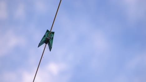 plastic clothespin on a clothesline against cloudy sky