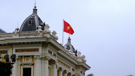 azotea de la ópera de hanoi con la bandera vietnamita ondeando, situada en la plaza de la revolución de agosto, primer plano cerrado