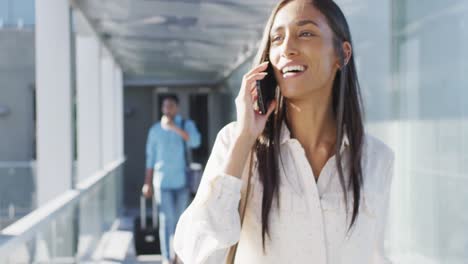 video de una feliz mujer biracial caminando y usando un teléfono inteligente