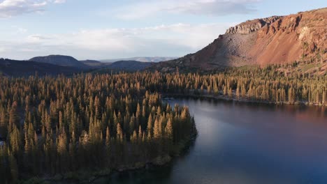 Absteigende-Luftaufnahme-Eines-Ruhigen-Alpensees-In-Den-Bergen-Bei-Sonnenuntergang