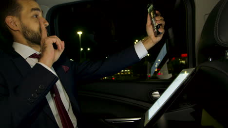 happy businessman dancing in the back seat of his limousine at night