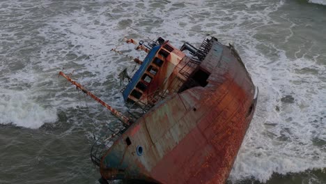 a wrecked rusty old ship washed ashore on a beach filmed in slow motion in lagos, nigeria