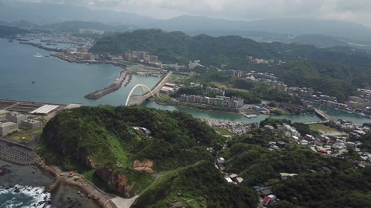 vista aérea cinematográfica de gran altura del parque de la isla heping, el puente y la ciudad de keelung, taiwán
