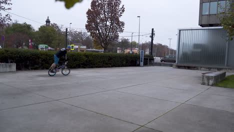 chico montando una bicicleta bmx en un skatepark, realizando el truco del ciclón
