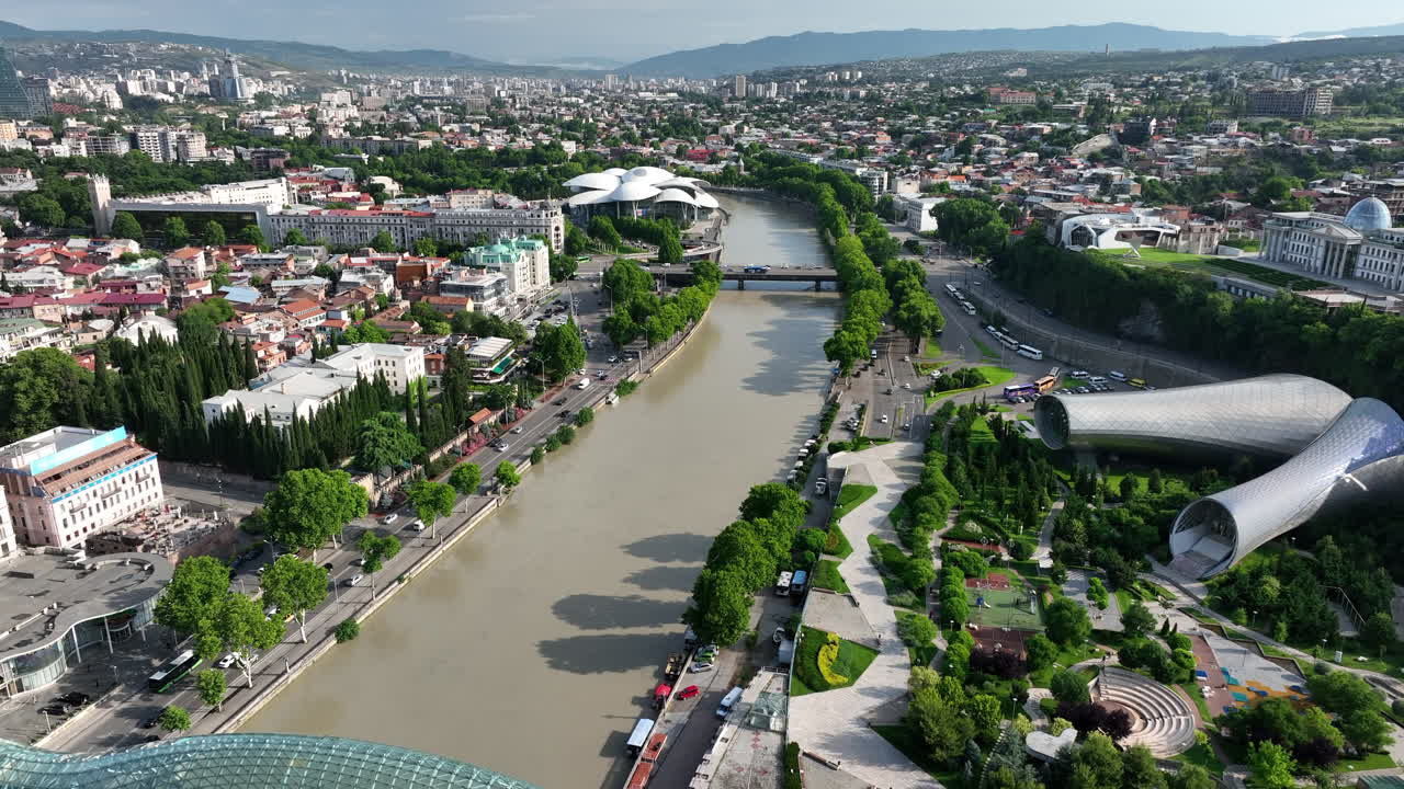 Drone footage over the Bridge of Peace, Rike Music Theatre and Exhibition Cente along the Kura River in Tbilisi, Georgia, Metekhi.