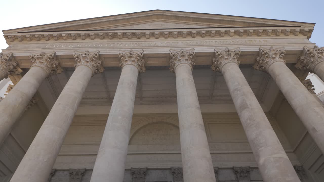 Inquadratura dal basso verso l'alto che rivela le monumentali colonne e il grandioso ingresso della chiesa più grande d'Ungheria, la Basilica di Esztergom