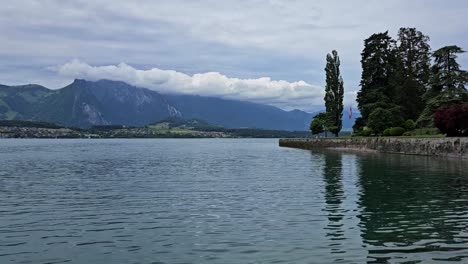 Blick-Auf-Den-See-In-Der-Schweiz-Mit-Bergen-Und-Wolken-Im-Hintergrund