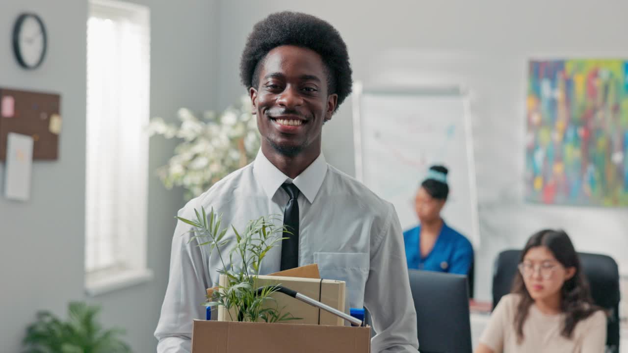 Man with afro hair quits corporate job leaves office with things packed in box leaves corporate, checks to make sure he took everything, quits job, retires, happy smiling