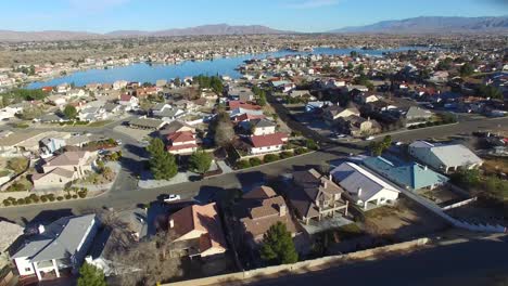 Antena-Sobre-Un-Barrio-Suburbano-En-El-Desierto-Con-Un-Lago-Artificial