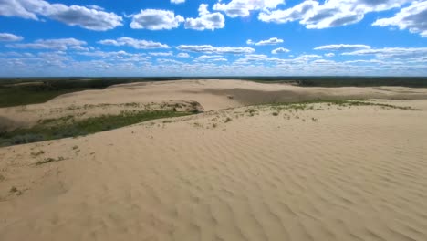 desert sand dune in alberta canada on a sunny day with some clouds in the sky