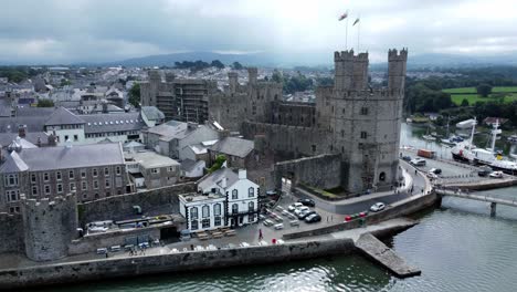 ancient caernarfon castle welsh harbour town aerial view medieval waterfront landmark slow right over river