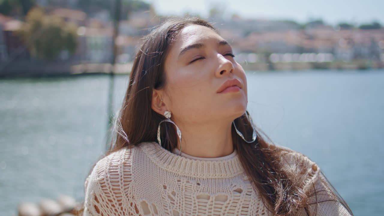 Dreamy lady standing waterfront in front marine city view closeup. Woman relax
