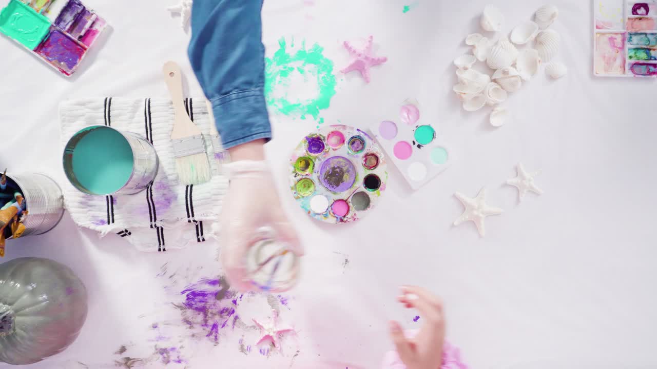 장식 된 해녀 할로윈 호박을 만들기 위해 아크릴 페인트로 공예 호박을 칠합니다.