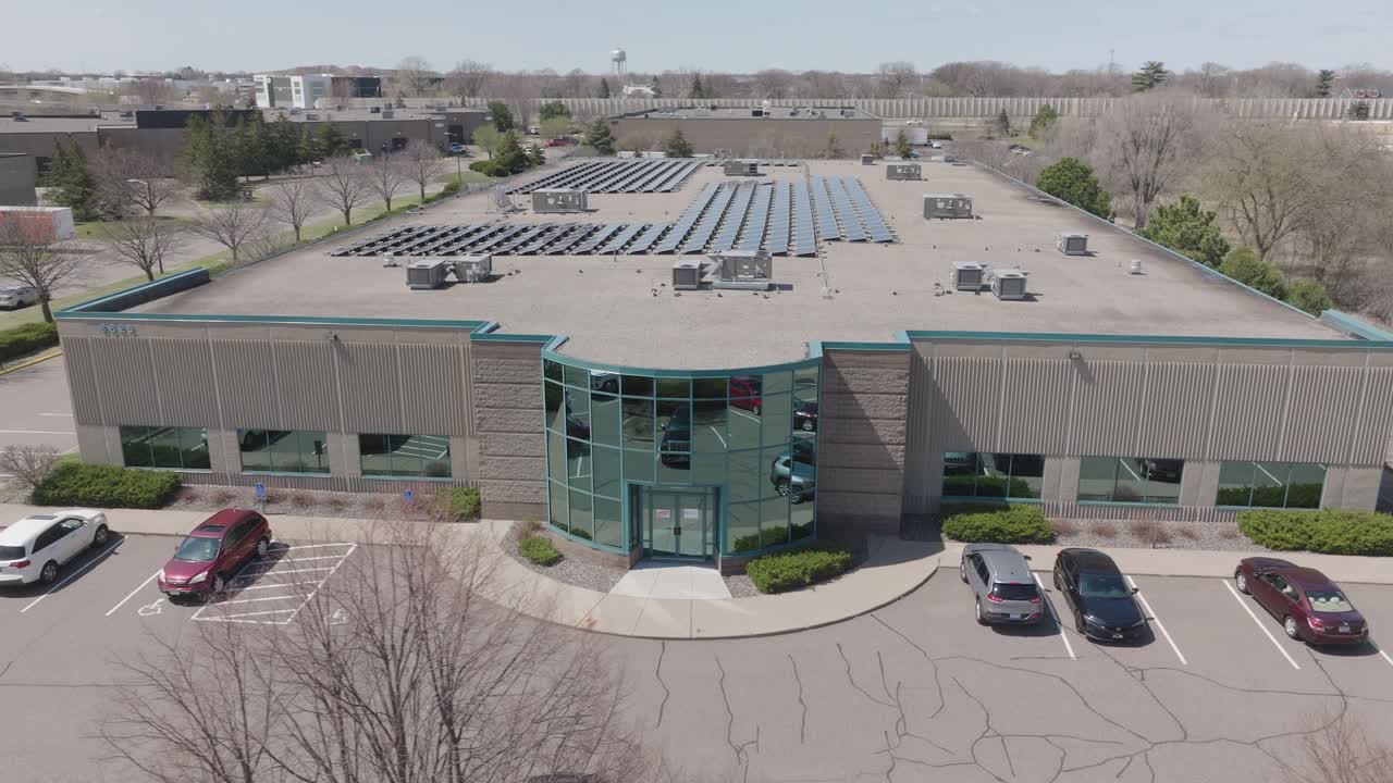 Panoramic Aerial View Of A Commercial Building With Solar Panels On The Rooftop.