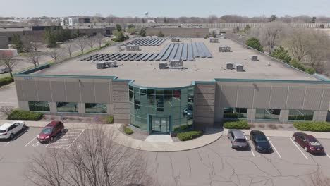 panoramic aerial view of a commercial building with solar panels on the rooftop.