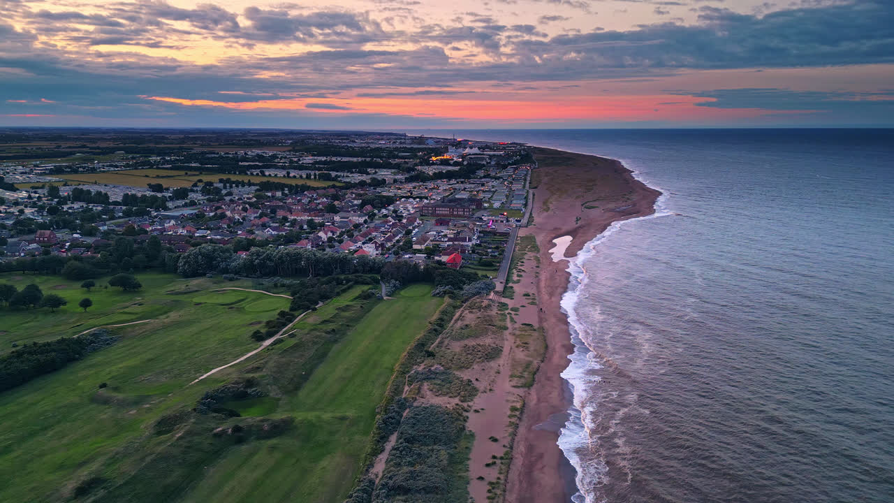 el video del avión no tripulado captura la costa de skegness al atardecer, con el parque de vacaciones, la playa y las caravanas