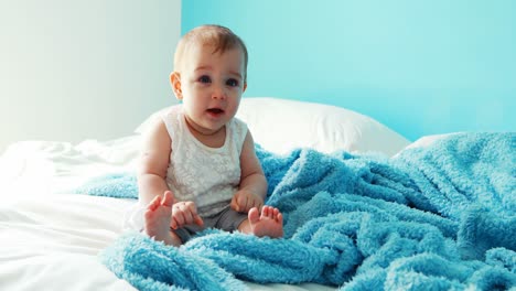 niña juguetona sentada en la cama