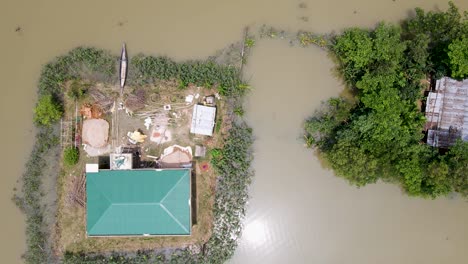 aerial shot of houses surrounded by flood water in a rural village area in bangladesh, south asia