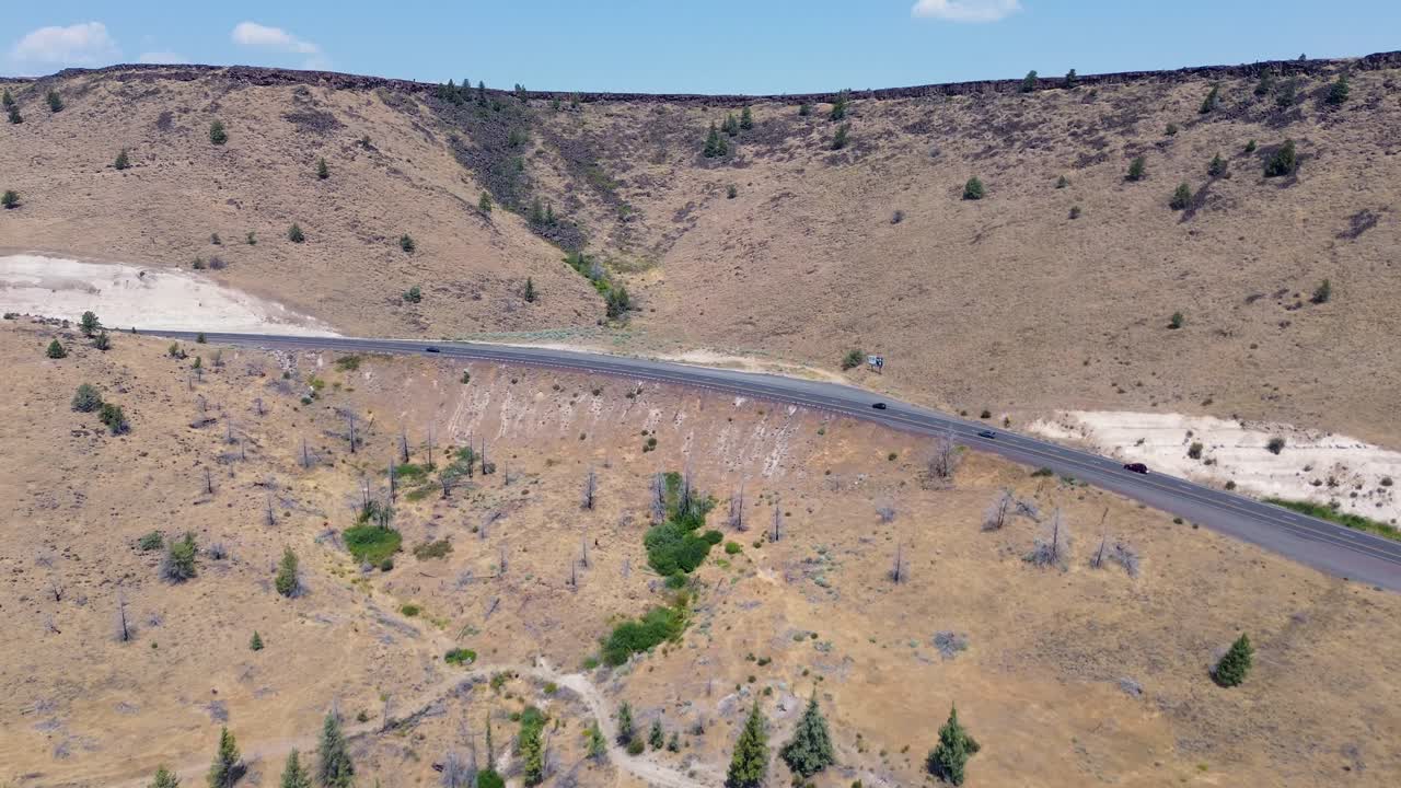 Drone aerial landscape with cars driving transport across highway freeway road nature mountains farm countryside Warm Springs Indian Reservation Oregon USA America travel tourism