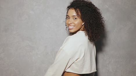 woman with curly hair and wireless headphones