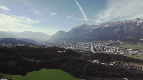 Beautiful-aerial-mountain-city-Innsbruck-between-alps,-Nordkette-on-sunny-day,-tourist-famous,-Austira