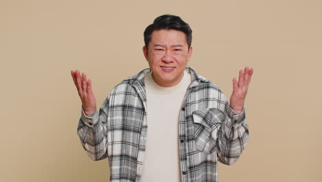 asian man trying hear you looking confused and frowning keeping arm near ear for louder voice