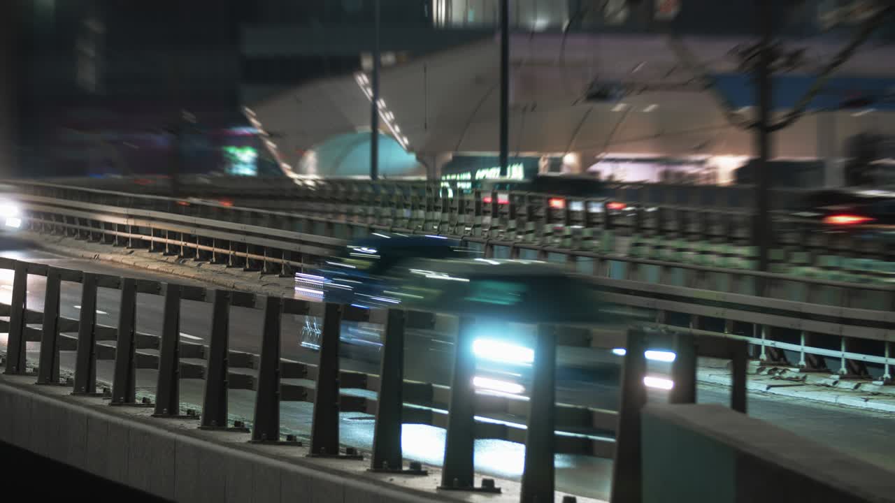 Primer plano de un timelapse de un atasco de tráfico en un intercambio vial con paso elevado por la noche, una intersección en una gran ciudad moderna al anochecer. Autopista urbana en timelapse. Coches moviéndose rápidamente, dejando estelas de luces.