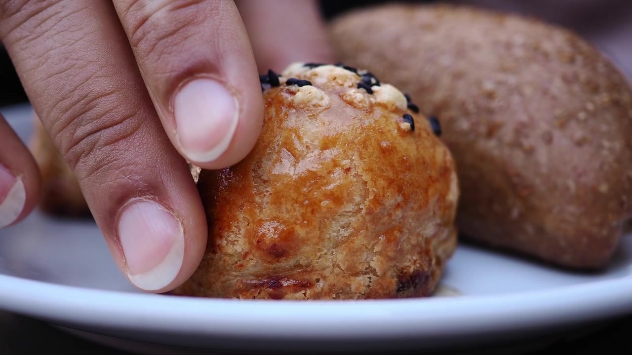 Mano che prende un rustico appena sfornato da un piatto