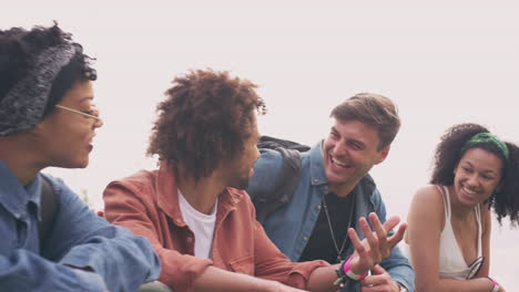 Group-Of-Young-Friends-Waiting-Behind-Barrier-At-Entrance-To-Music-Festival-Site