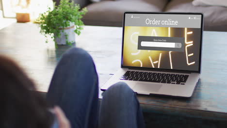 knees of woman at table using laptop, online shopping during sale, slow motion