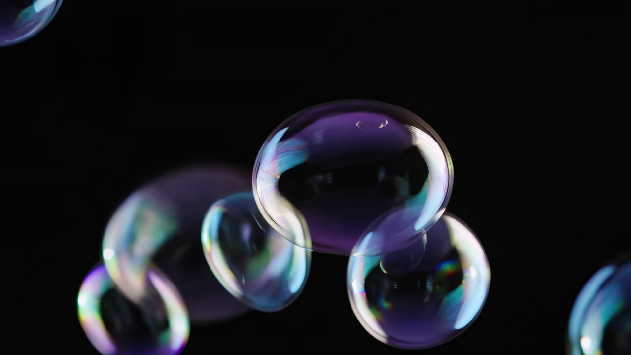 Translucent soap bubbles drift and overlap against deep black backdrop, with larger sphere near center and smaller bubbles around it, shimmering colors, soft highlights, subtle depth, calm studio mood