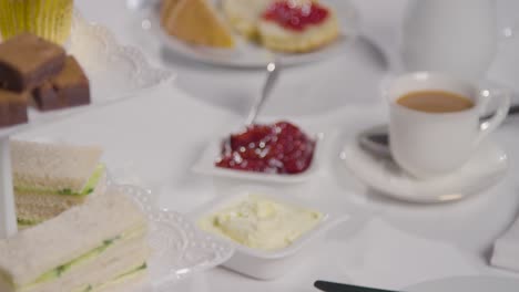 Foto-De-Estudio-De-Té-Tradicional-Británico-De-La-Tarde-Con-Sándwiches,-Pastel,-Bollos,-Crema-Y-Mermelada-3