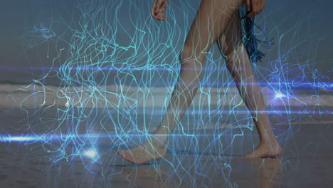 animation of light trails over caucasian woman walking at beach