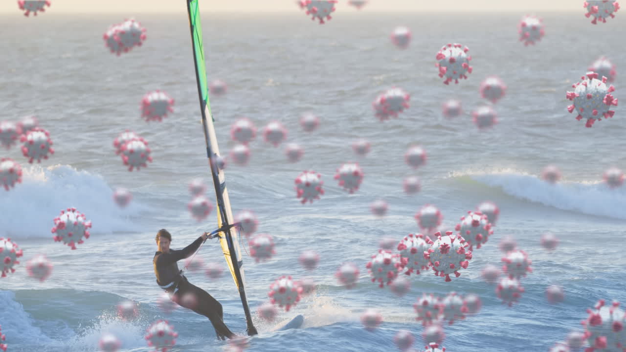 코로나19 세포가 인간을 상대로 움직이는 디지털 복합 비디오 배경에는 바다에서 윈드서핑이 있습니다.