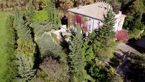 Castle-covered-with-autumnal-plant,-the-garden-is-filled-with-colored-green,-red,-pink,-orange,-yellow-leaves-of-autumn