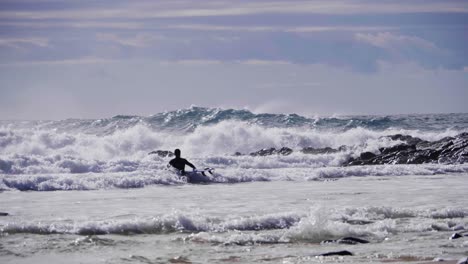 A-surfer-entering-the-waves-of-Crescent-Head---NSW-Australia---Slow-motion