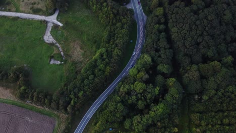 cars drive through forest and fields in the countryside