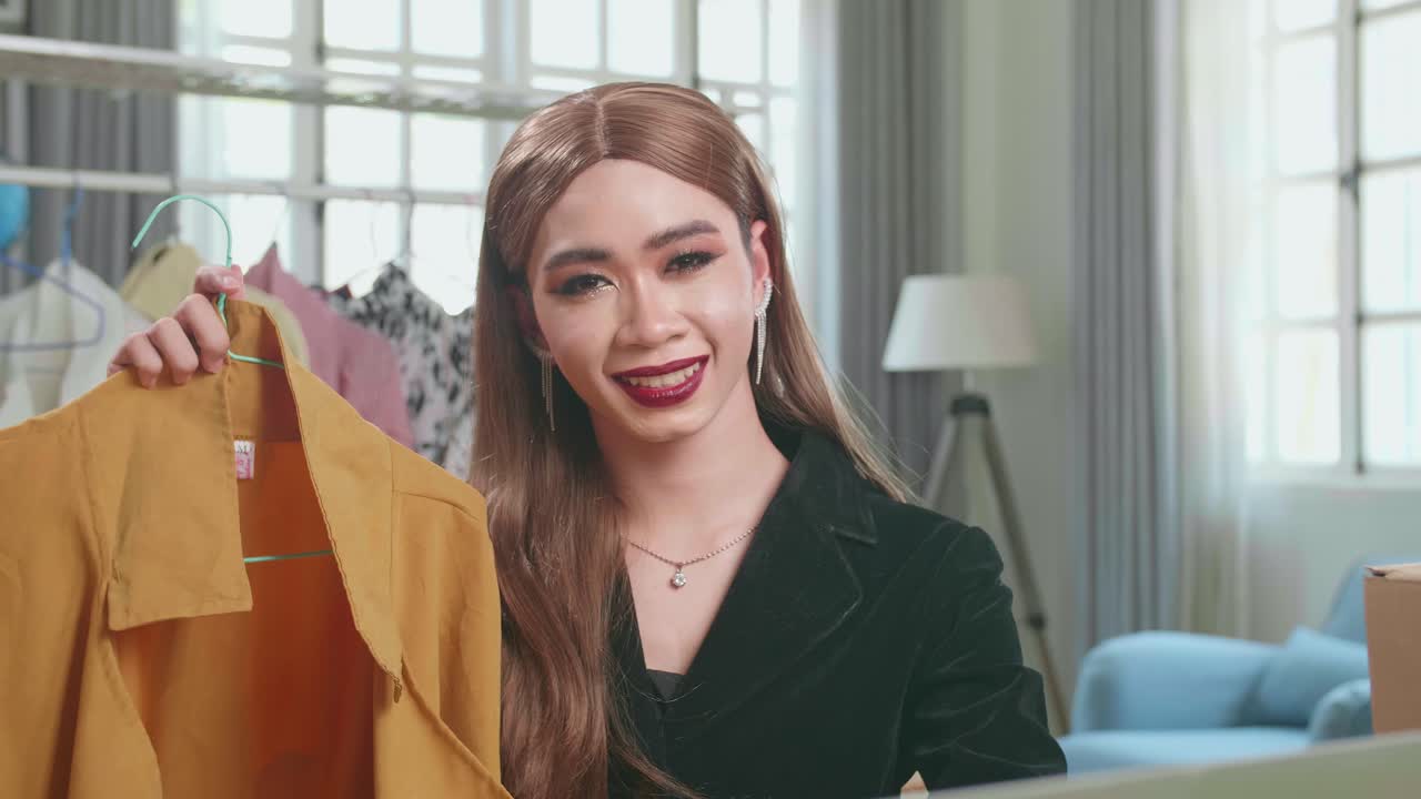 Young Asian Transgender Woman Selling Clothes Online By Live Streaming, Looking And Smiling To Camera. Selling It Online Live Streaming Concept