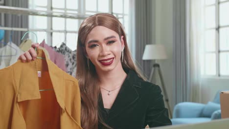 young asian transgender woman selling clothes online by live streaming, looking and smiling to camera. selling it online live streaming concept