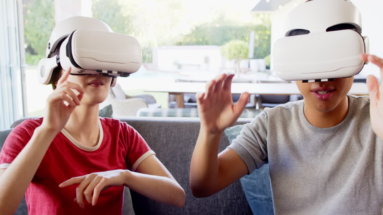 Using VR headsets, two people interacting with virtual environment on sofa