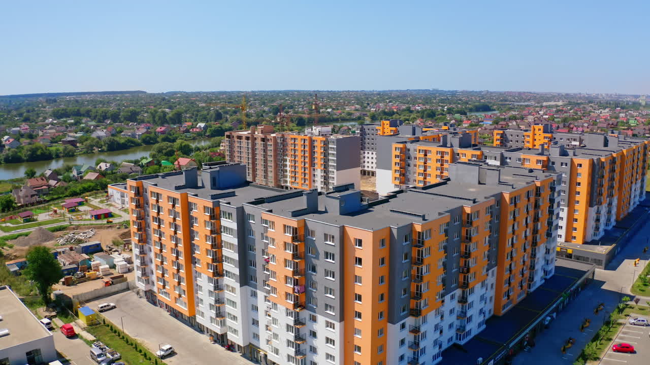 New residential complex with high-rise buildings. Modern multi-storey buildings with colorful walls. Construction site of new residential area at sunlight.