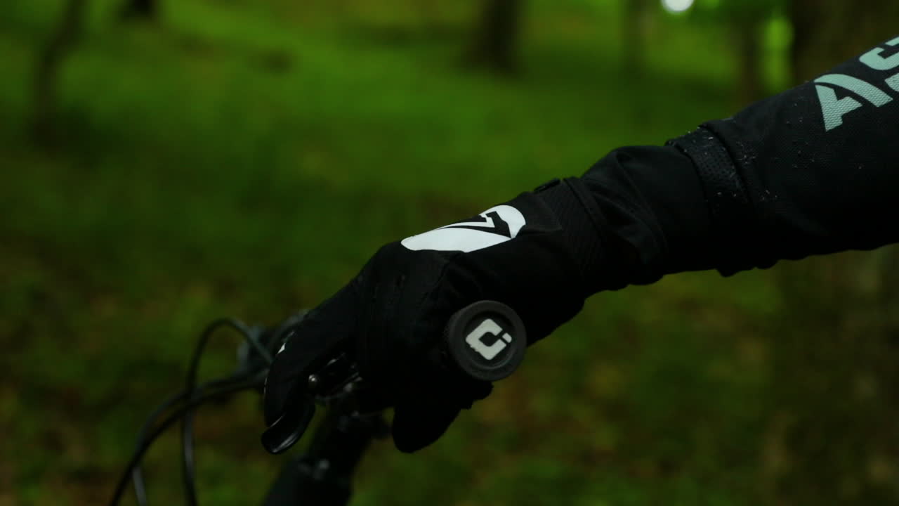 vista de primer plano del manillar de bicicleta de montaña y detalle en la mano del ciclista