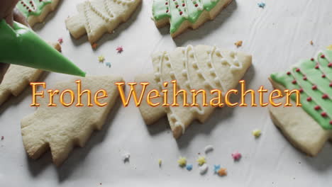 frohe weihnachten text in orange over decorated christmas cookies on white background